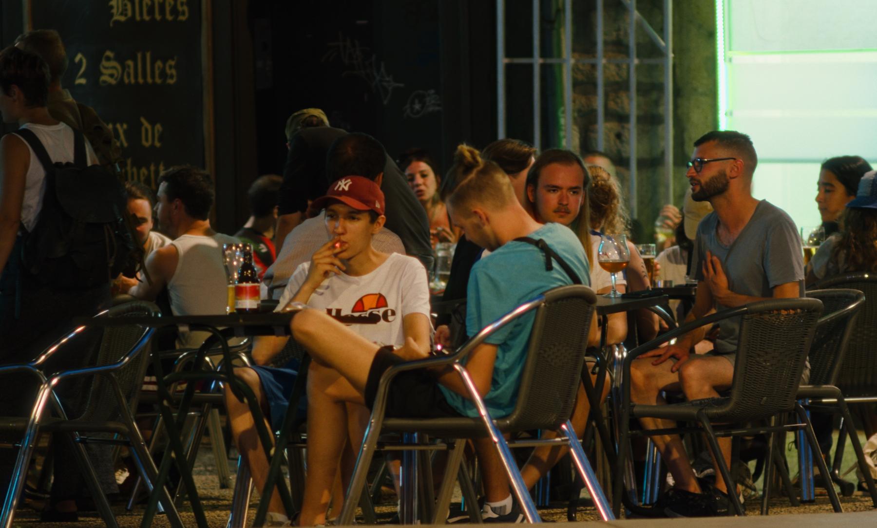 Photogramme : une terrasse de bar animée dans la chaleur du soir.